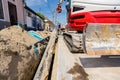 Small excavator with front blade is carry long HDPE pipe over trench, water supply network Royalty Free Stock Photo