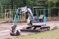 Small excavator at work making garden pond