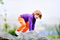 A small fair-haired girl in a purple sweater