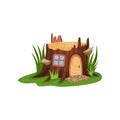 Small fairy-tale house in form of old stump surrounded by tall green grass. Home with wooden arched door and square Royalty Free Stock Photo