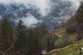 Small farm in the Alpine Oberbayern region of Germany among mountain hills covered with trees with colourful autumn foliage