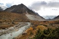 A small fast mountain white river runs among the stones in a beautiful mountain valley. Autumn landscape with clouds and rocks Royalty Free Stock Photo