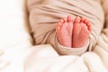 Small feet of the child closeup. Baby wrap. Sleeping newborn baby in a basket