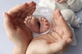 Small feet of a newborn in hands of parents. Loving palms of the hands of mother Royalty Free Stock Photo