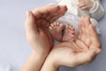 Small feet of a newborn in the hands of parents. Loving palms of hands of mother Royalty Free Stock Photo