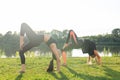 Small female fitness group doing yoga in park on a sunny day Royalty Free Stock Photo