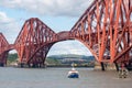 A small ferry boat next to the Forth Bridge in Queensberry Royalty Free Stock Photo