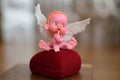 A small figure of an angel sitting on or near a jewelry box close up