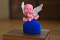 A small figure of an angel sitting on or near a jewelry box close up