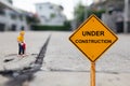 Small figure digging concrete street with Under Construction message.