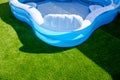 A small fillable plastic, rubber pool in an outdoor garden