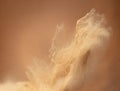 Small Fine size Sand flying explosion, Golden grain wave explode, abstract cloud fly. Yellow colored sand splash throwing in Air.