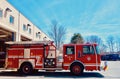 Shiny Red Fire Engine Moving Out of Fire Station, side view