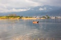 In the morning, the small fishing boat on the sea in the golden sun, the misty clouds in the distance