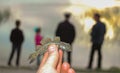 small fish goby in hand against the background of silhouettes of people in the evening near Lake Yalpug, Ukraine