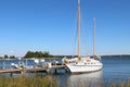 Small fishing boat is anchored at a dock in a calm, blue marina Royalty Free Stock Photo