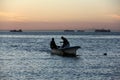 Small fishing boat on background of the sunset sky, silhouettes of fishermen, La Paz, BCS, Mexico Royalty Free Stock Photo