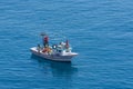 Small fishing boat with nets follows the sea surface of the Mediterranean Sea view from above aerial away distance