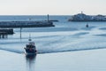 Small fishing boat in the port of Svolvaer on the Lofoten islands in Norway with snow on clear day with blue sky Royalty Free Stock Photo