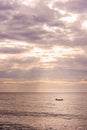 Small fishing boat with two fishermen on the sea near Puducherry in South India during sunrise