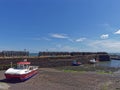 Small Fishing Boats alongside the Harbour Walls of Johnshaven Fishing Village at Low Tide Royalty Free Stock Photo