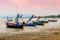 Small fishing boats anchor at beach in cloudy sunset sky