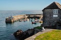 Small fishing boats in Coverack harbour. The old post office and a herring gull are in the foreground Royalty Free Stock Photo