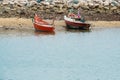 Small fishing boats float on see near cement breakwater Royalty Free Stock Photo