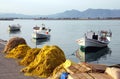 Small fishing boats floating in the pretty harbor in Nafplio in Greece with nets Royalty Free Stock Photo