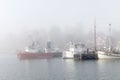 Small fishing boats in the harbor a foggy morning Royalty Free Stock Photo