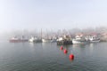 Small fishing boats in the harbor a foggy morning Royalty Free Stock Photo