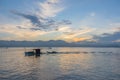 Small fishing boats and lonely man in the bay with magic of the sky and clouds at sunrise Royalty Free Stock Photo