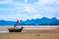 Small fishing boats on sand Beach during low tide with cloudy blue sky Royalty Free Stock Photo