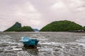 Small fishing boats on sand beach during low tide with cloudy blue sky Royalty Free Stock Photo