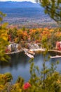 Small fishing dock and gazebo on a peaceful lake, surrounded by colorful leaves and fall foliage. Mohonk Preserve