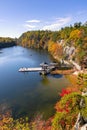 Small fishing dock and gazebo on a peaceful lake, surrounded by colorful leaves and fall foliage. Mohonk Preserve