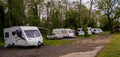 Caravans and a lone motor home in a line at a small rural campsite