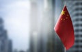 A small flag of China on the background of a blurred background Royalty Free Stock Photo