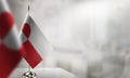 Small flags of the Greenland on an abstract blurry background