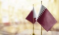 Small flags of the Qatar on an abstract blurry background