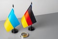 Small flags of Ukraine and Germany on gray background with compass Royalty Free Stock Photo