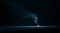 A small flame burns on a flat surface in a dark, minimalistic setting Royalty Free Stock Photo