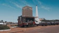 Small food truck, with the cnps building and the independence monument at the Yaounde city hall in the background