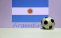 Small football on the white floor and Argentinean nation flag with the text of Argentina background. Royalty Free Stock Photo