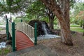 Small footbridge and waterfall in Macintosh island park. Royalty Free Stock Photo