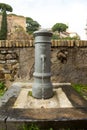 A small fountain of fresh and clean water for drinking on one of the streets of Rome in Italy. Classic Roman fountain with Royalty Free Stock Photo