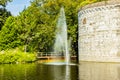 Small fountain with a jet of water reflecting a rainbow in a pond, the Rondeel of the old city wall in the Maastricht city park Royalty Free Stock Photo