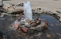 A small fountain lined with stones in the park. Royalty Free Stock Photo