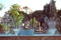 Small fountain and pool in a park with grass and trees around it Royalty Free Stock Photo