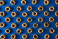 Small fresh bagels with poppy seeds on a blue background